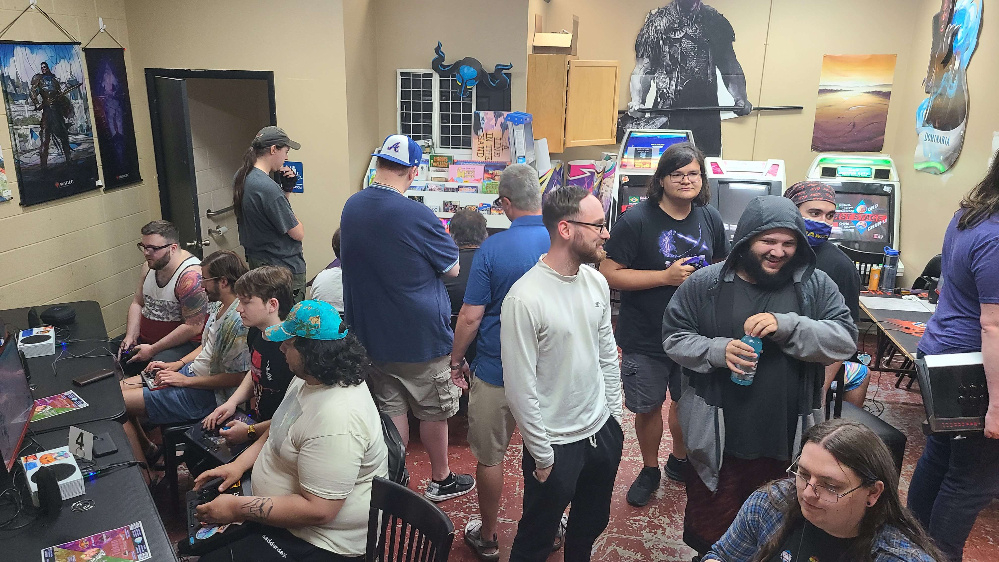 Image of a Saturday meetup for Knoxville, TN's Fighting Game Community. Roughly 15 players pictured in a card shop playing various fighting games.